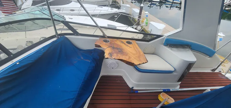 Slide: The Image of 1990 Carver 38 Santego yacht interior with custom wood table and blue seating. - 15