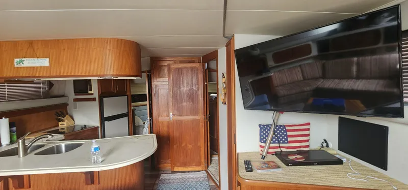 Slide: The Image of Interior of a 1990 Carver 38 Santego yacht with kitchen, TV, and American flag decor. - 23