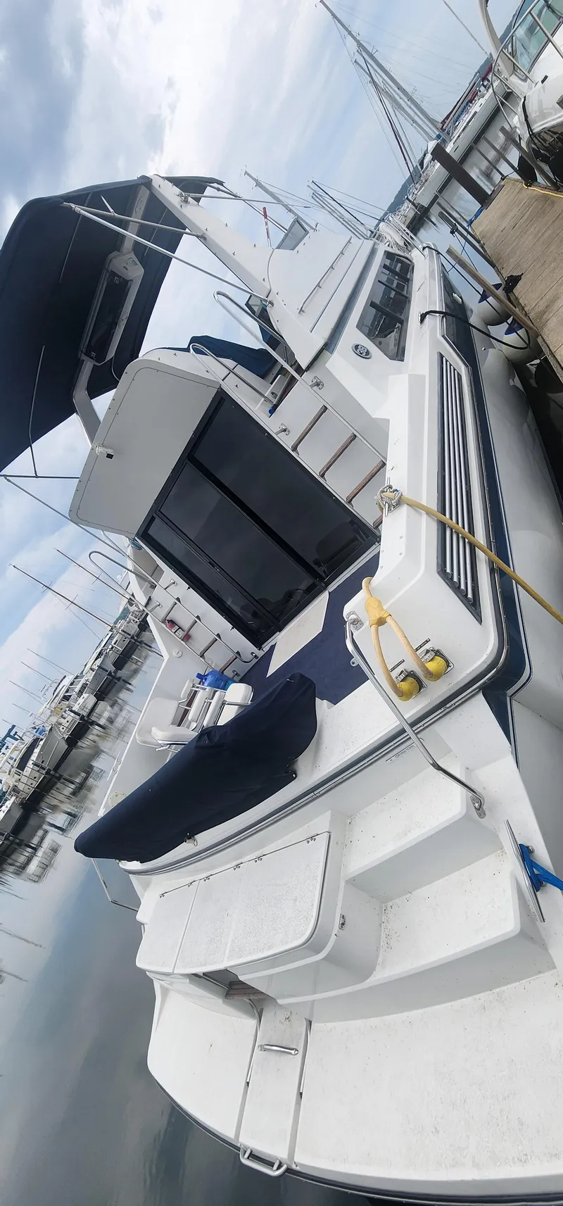 Slide: The Image of 1990 Carver 38 Santego yacht docked at marina, featuring spacious deck and canopy. - 38