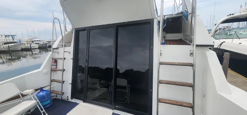 Slide: The Image of 1990 Carver 38 Santego yacht with glass doors and ladder, docked at marina. - 5