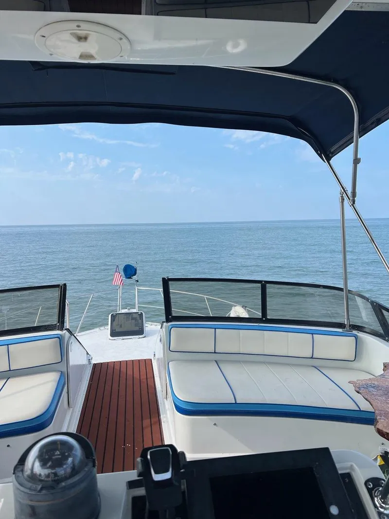 Slide: The Image of 1990 Carver 38 Santego yacht interior with ocean view, featuring cushioned seating and canopy. - 6