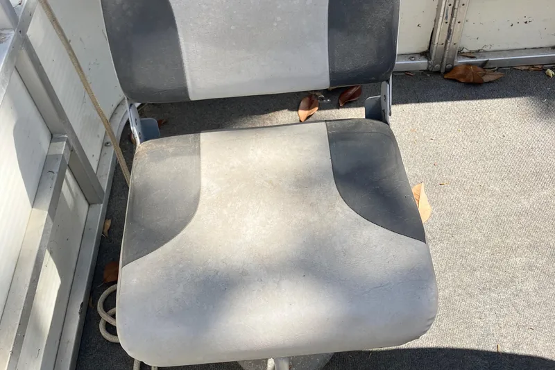Slide: The Image of Gray boat seat on a 1996 Smoker Craft 820, with fallen leaves nearby. - 11
