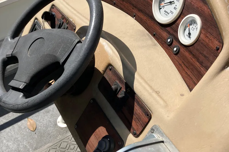 Slide: The Image of 1996 Smoker Craft 820 boat dashboard with steering wheel and gauges. - 15