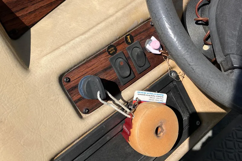 Slide: The Image of 1996 Smoker Craft 820 boat dashboard with steering wheel and control switches. - 16