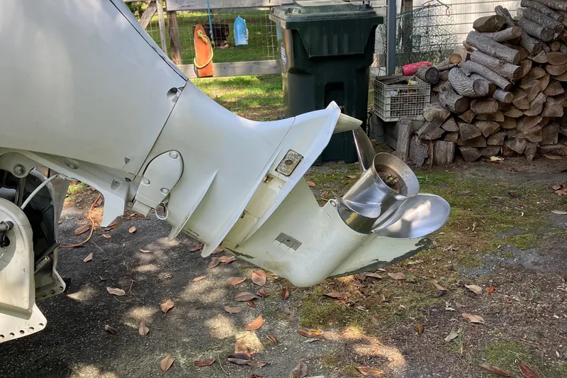 Slide: The Image of Outboard motor of a 1996 Smoker Craft 820 boat, with visible propeller and surrounding yard. - 22