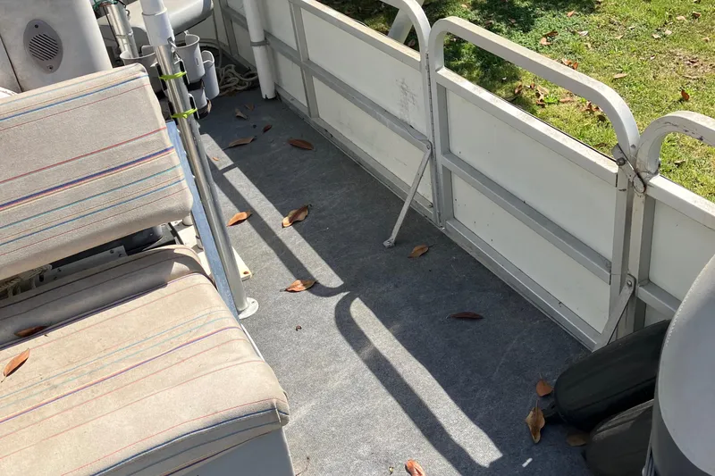 Slide: The Image of Interior of a 1996 Smoker Craft 820 boat with striped seats and scattered leaves. - 5