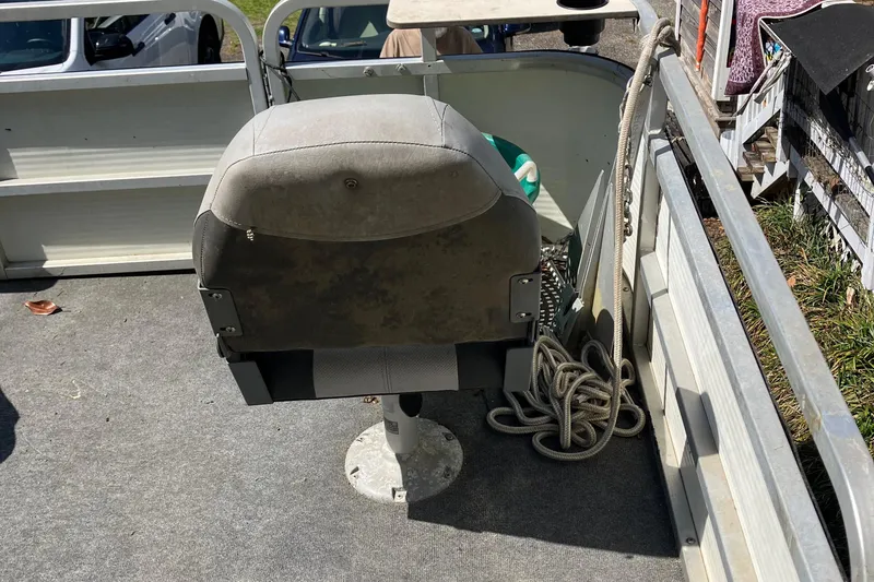 Slide: The Image of 1996 Smoker Craft 820 boat interior with a single seat and coiled rope. - 6