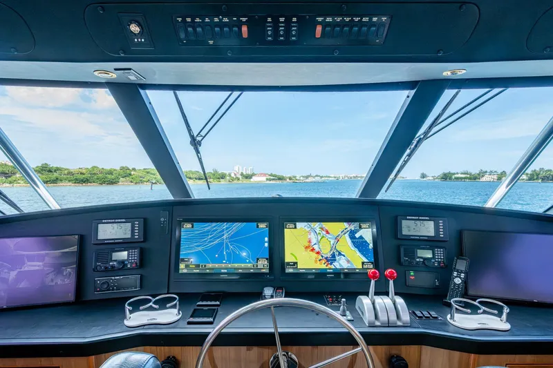 Slide: The Image of Cockpit of 2005 Viking 61 yacht with navigation screens and controls, overlooking serene waters. - 20