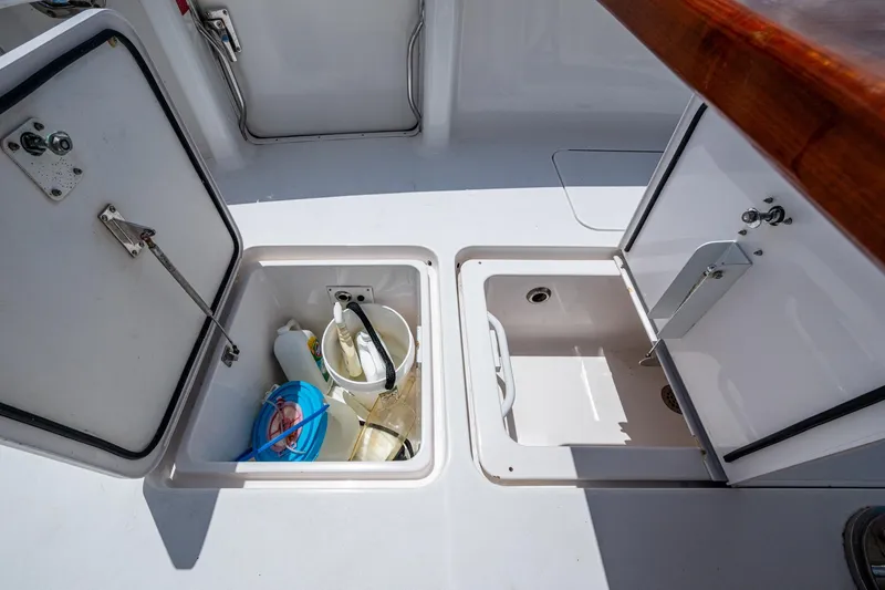 Slide: The Image of Open storage compartments on a 2005 Viking 61 boat deck, containing cleaning supplies. - 23