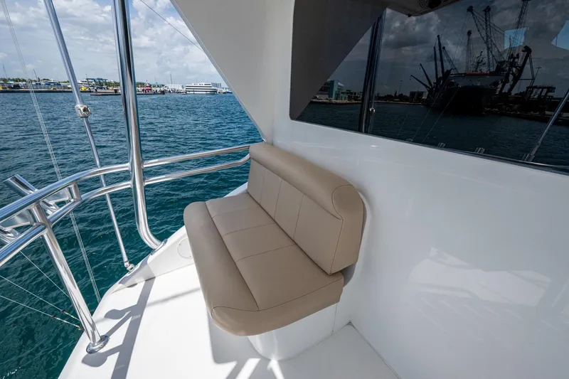 Slide: The Image of 2005 Viking 61 yacht with beige seating, overlooking a marina and cranes. - 34