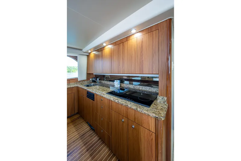 Slide: The Image of Luxurious 2005 Viking 61 yacht kitchen with wood cabinets and granite countertops. - 39