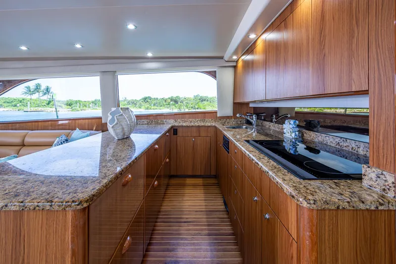 Slide: The Image of Luxurious 2005 Viking 61 yacht kitchen with granite countertops and wooden cabinetry. - 40