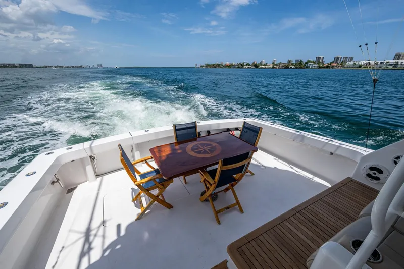 Slide: The Image of Aft deck of 2005 Viking 61 yacht with table and chairs, cruising on open water. - 56