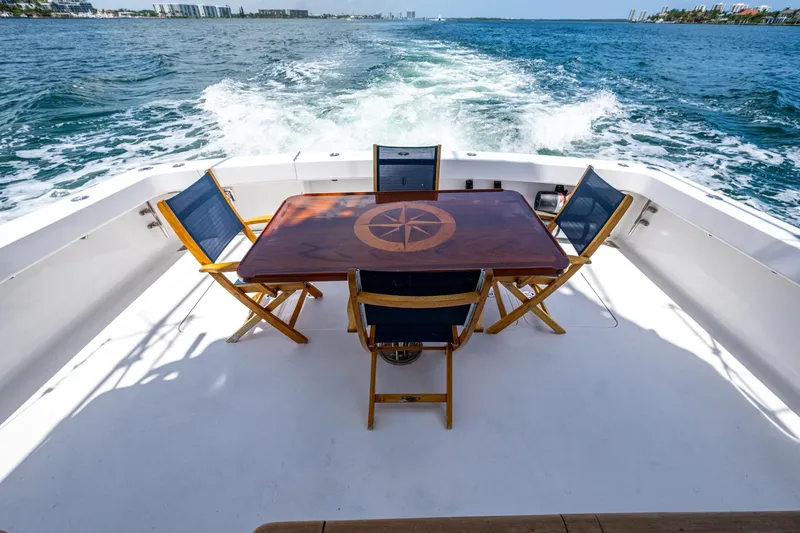 Slide: The Image of 2005 Viking 61 yacht deck with wooden table and chairs, ocean view. - 59
