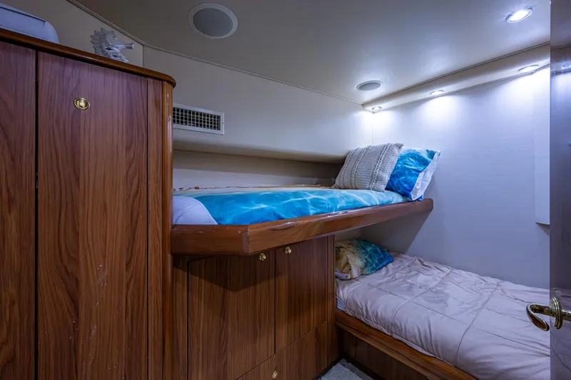Slide: The Image of Cozy cabin with bunk beds in 2005 Viking 61 yacht, featuring wood paneling and soft lighting. - 75