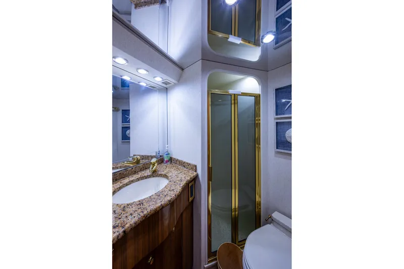 Slide: The Image of Luxurious bathroom in 2005 Viking 61 yacht with granite countertop and gold-accented shower. - 77