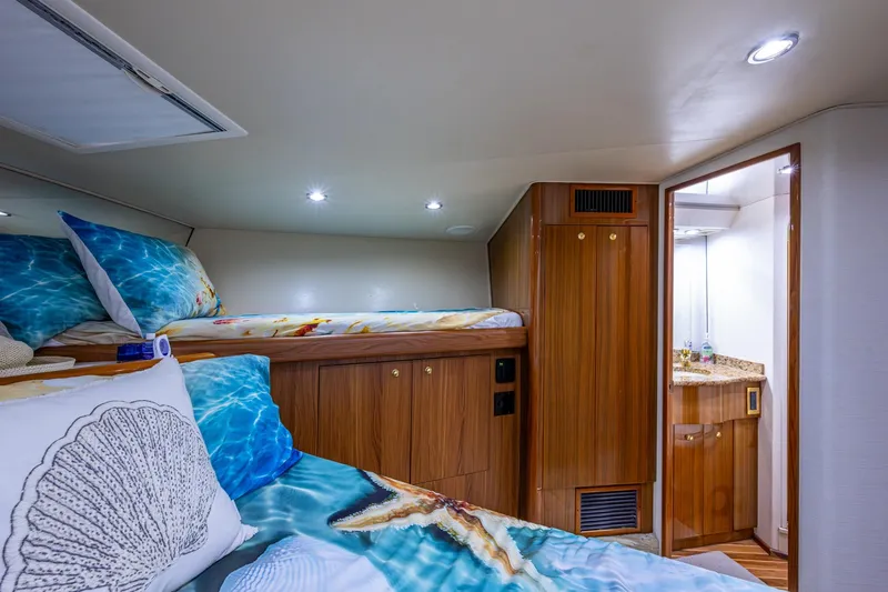 Slide: The Image of Luxurious cabin interior of 2005 Viking 61 yacht with cozy bedding and wooden finishes. - 81
