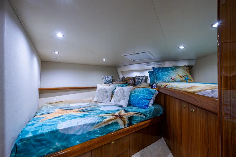 Slide: The Image of Luxurious 2005 Viking 61 yacht cabin with starfish-themed bedding and elegant wood finishes. - 84