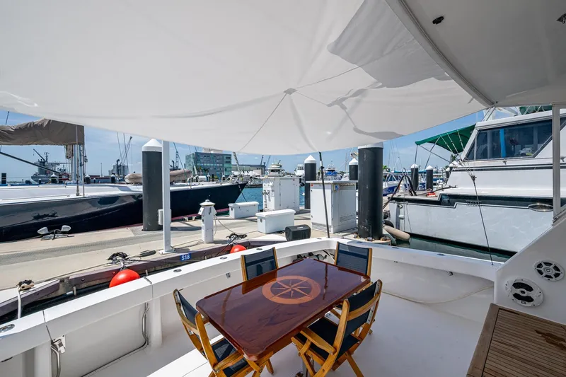 Slide: The Image of 2005 Viking 61 yacht deck with shaded seating area at marina. - 86