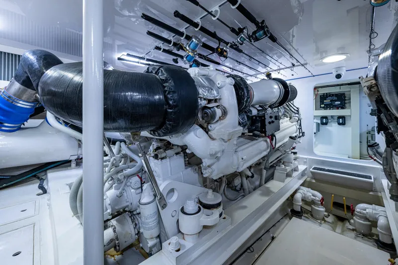 Slide: The Image of Engine room of a 2005 Viking 61 yacht, showcasing complex machinery and piping. - 99