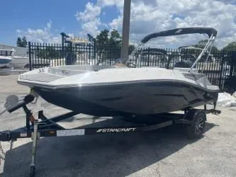 Slide: The Image of 2025 Starcraft SV 16 boat on trailer, parked outdoors under a partly cloudy sky. - 4