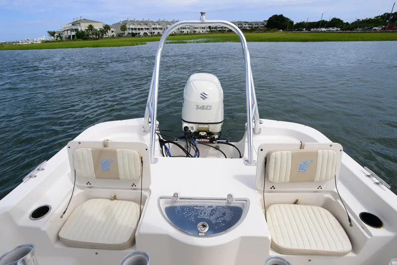 Slide: The Image of 2017 Carolina Skiff 218 DLV boat interior with Suzuki 140 engine on calm water. - 17