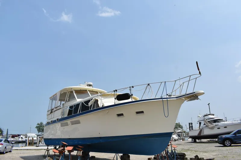 The Image of 1967 Hatteras 41 Twin Cabin yacht on dry dock under clear blue sky. - 0