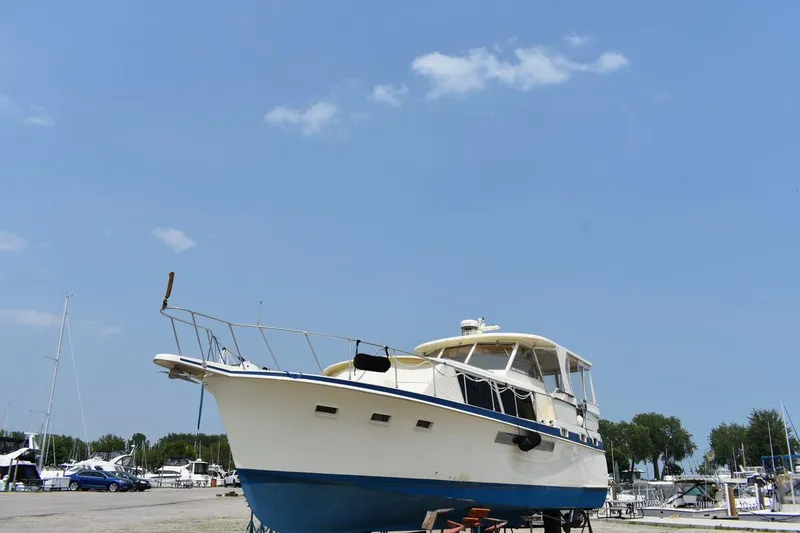 Slide: The Image of 1967 Hatteras 41 Twin Cabin yacht on land under clear blue sky. - 2