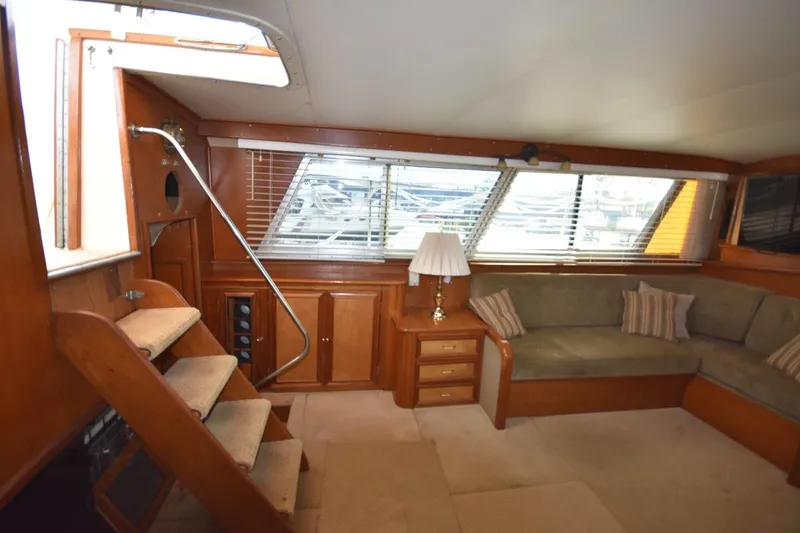 Slide: The Image of 1967 Hatteras 41 Twin Cabin interior with wood paneling, sofa, and stairs. - 21