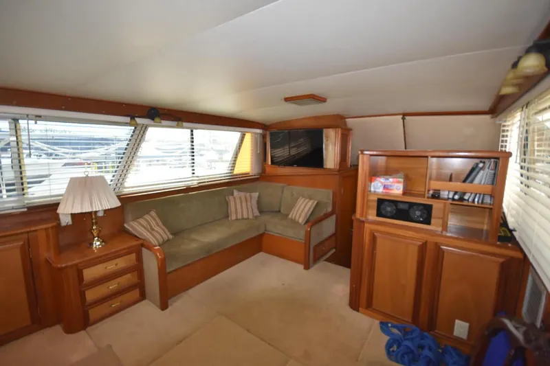 Slide: The Image of 1967 Hatteras 41 Twin Cabin interior with cozy seating, wooden cabinetry, and ample natural light. - 25