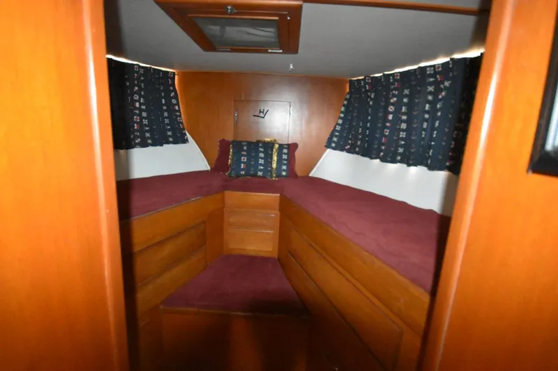Slide: The Image of Interior of 1967 Hatteras 41 Twin Cabin with wooden finish and maroon bedding. - 29