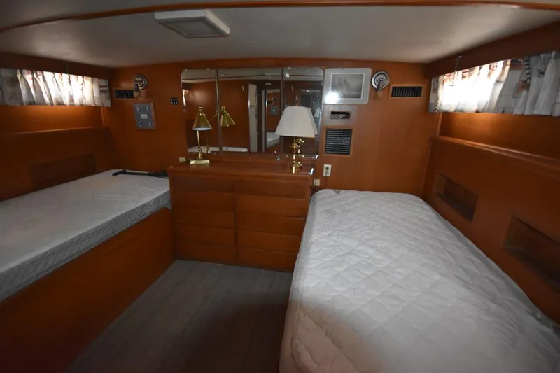 Slide: The Image of 1967 Hatteras 41 Twin Cabin interior with twin beds, wooden cabinetry, and nautical decor. - 34