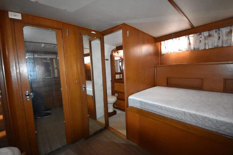 Slide: The Image of 1967 Hatteras 41 Twin Cabin interior with wood paneling, bed, and bathroom. - 35