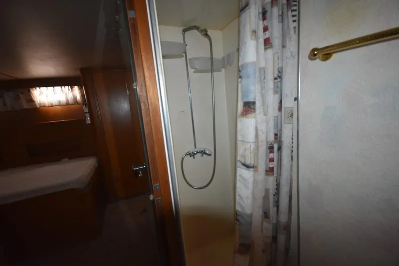 Slide: The Image of 1967 Hatteras 41 Twin Cabin shower area with nautical-themed curtain. - 38