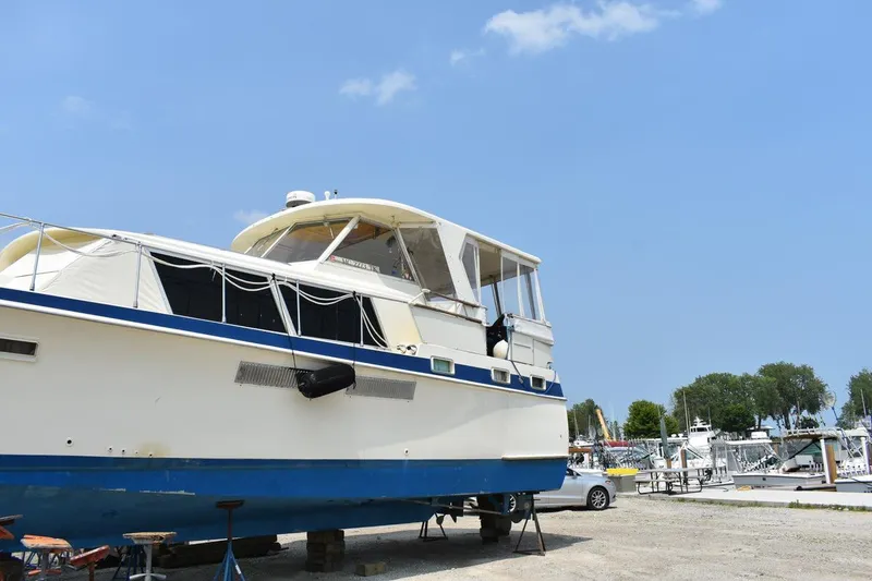 Slide: The Image of 1967 Hatteras 41 Twin Cabin yacht on land, clear sky, marina background. - 4
