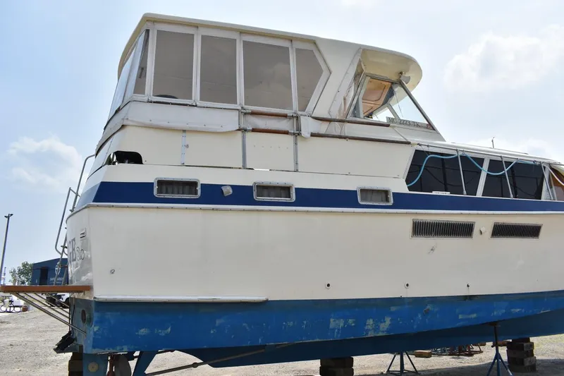 Slide: The Image of 1967 Hatteras 41 Twin Cabin boat on dry dock, white and blue exterior. - 8