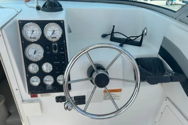 Slide: The Image of 2001 Seaswirl Striper 2601 Walkaround O/B helm with gauges and steering wheel. - 7