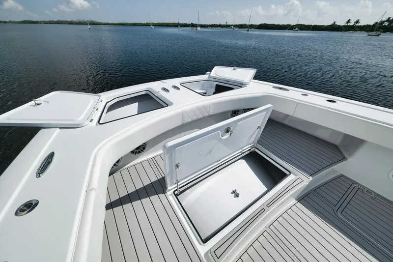 Slide: The Image of Freeman 47 boat deck with open storage compartments, 2022 model, on calm water. - 19
