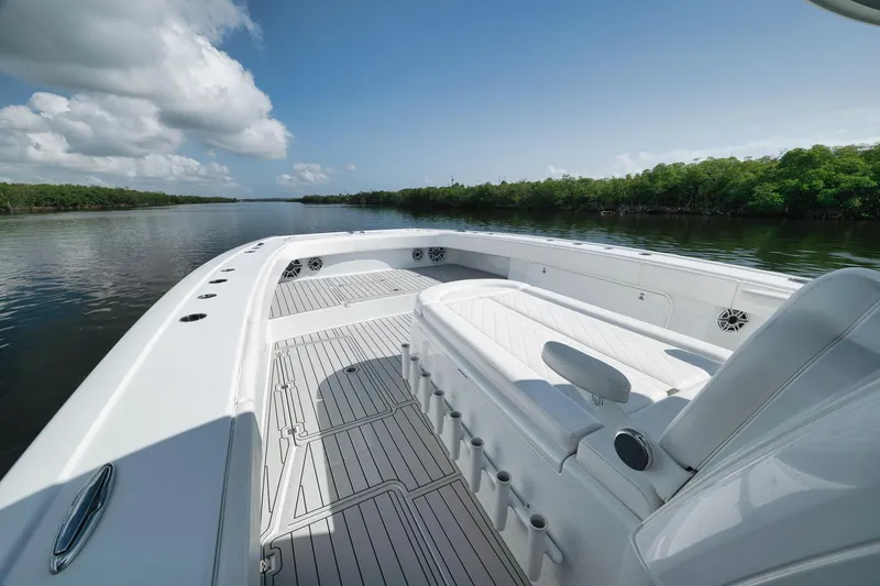 Slide: The Image of 2022 Freeman 47 boat interior with sleek white seating and spacious deck on a calm river. - 21