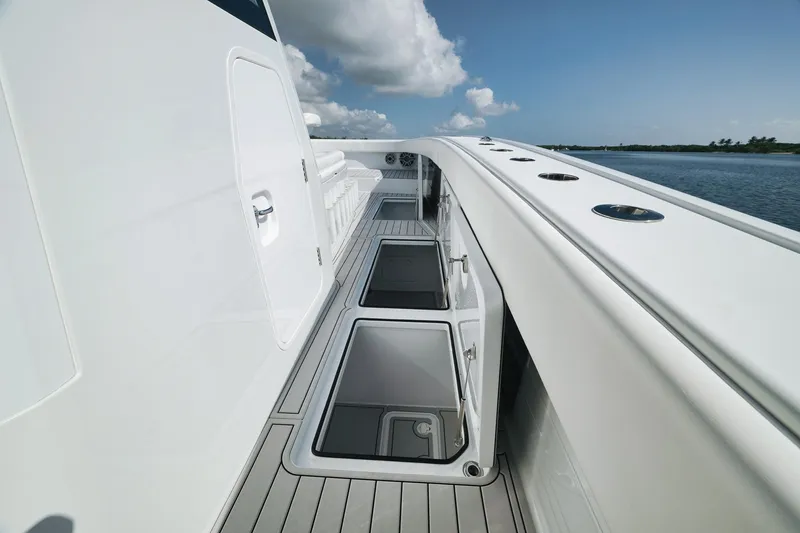 Slide: The Image of Freeman 47 boat deck with open storage compartments, 2022 model, on calm water. - 27