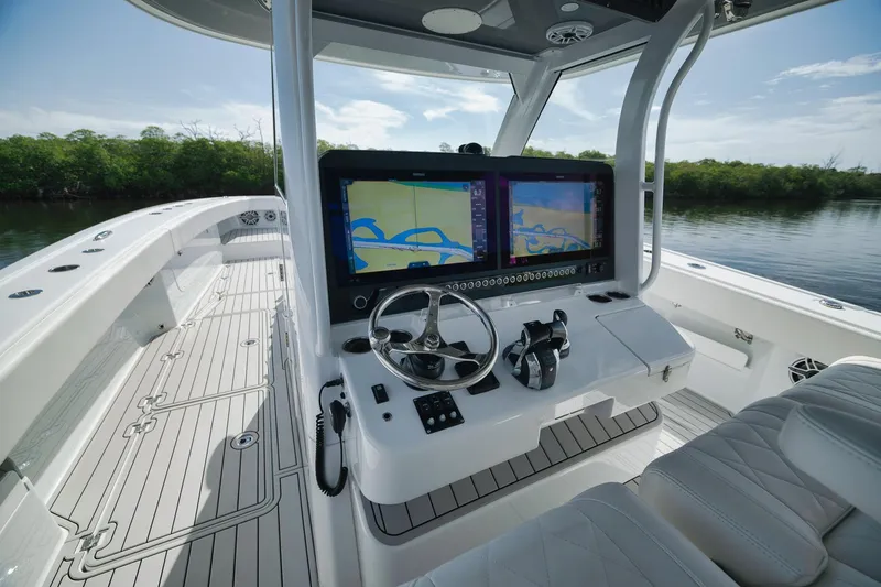 Slide: The Image of 2022 Freeman 47 boat cockpit with dual navigation screens and sleek steering wheel. - 32