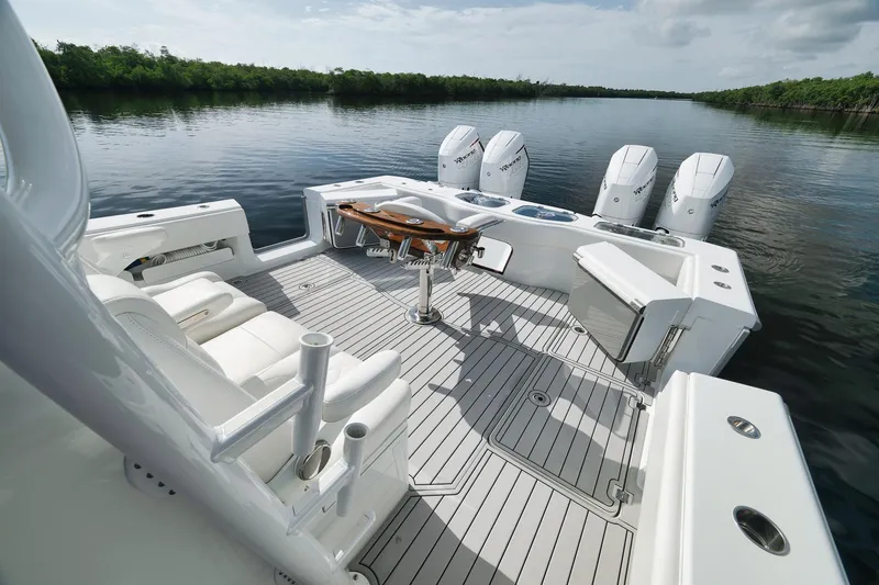 Slide: The Image of 2022 Freeman 47 boat deck with seating, fishing setup, and four outboard motors on calm water. - 36