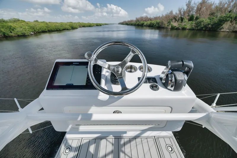 Slide: The Image of 2022 Freeman 47 boat helm with steering wheel and navigation system on a calm river. - 46