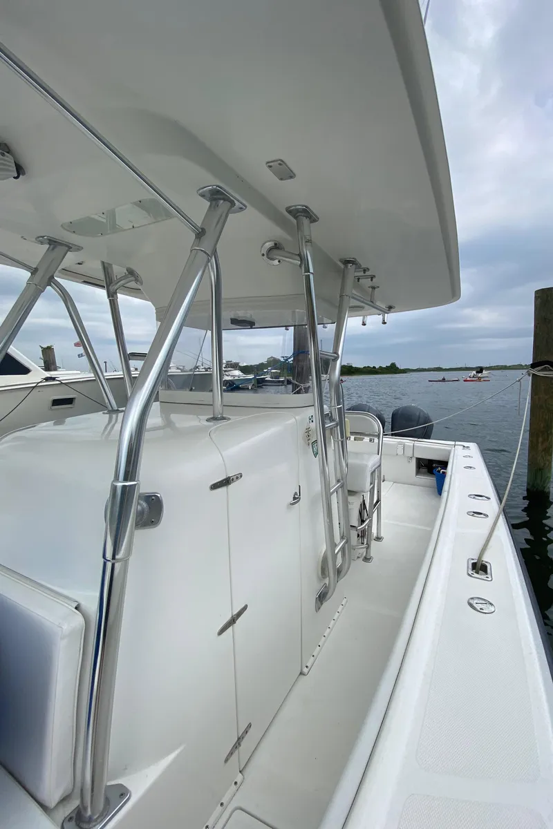 Slide: The Image of 2000 Venture 34 Open boat docked, featuring sleek white design and stainless steel railings. - 13