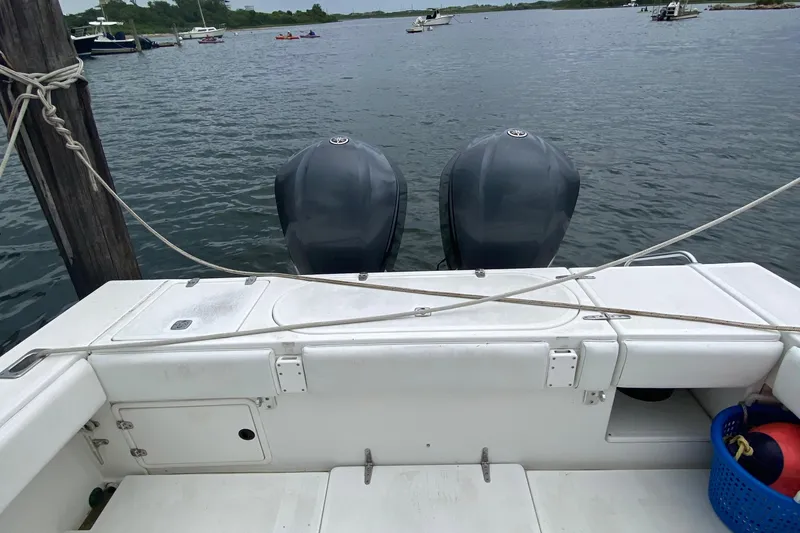 Slide: The Image of 2000 Venture 34 Open boat with dual outboard motors docked on calm water. - 16