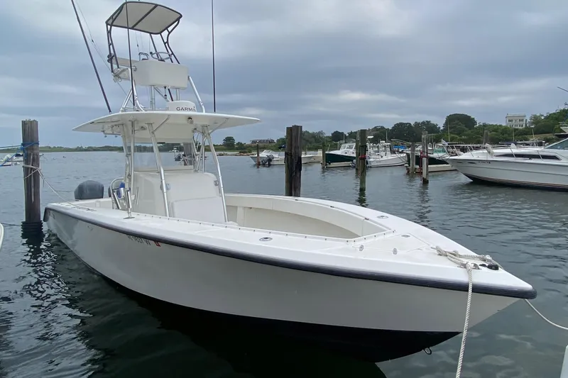 Slide: The Image of Venture 34 Open 2000 boat docked in a marina under cloudy skies. - 17