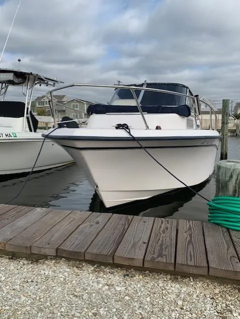 Slide: The Image of Grady-White Adventure 208 boat docked, 2000 model, with cloudy sky background. - 2