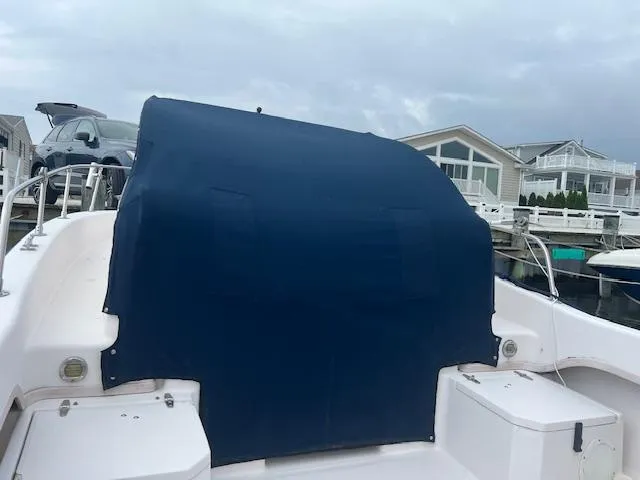 Slide: The Image of Grady-White Adventure 208 boat, 2000 model, with blue cover at a marina. - 9