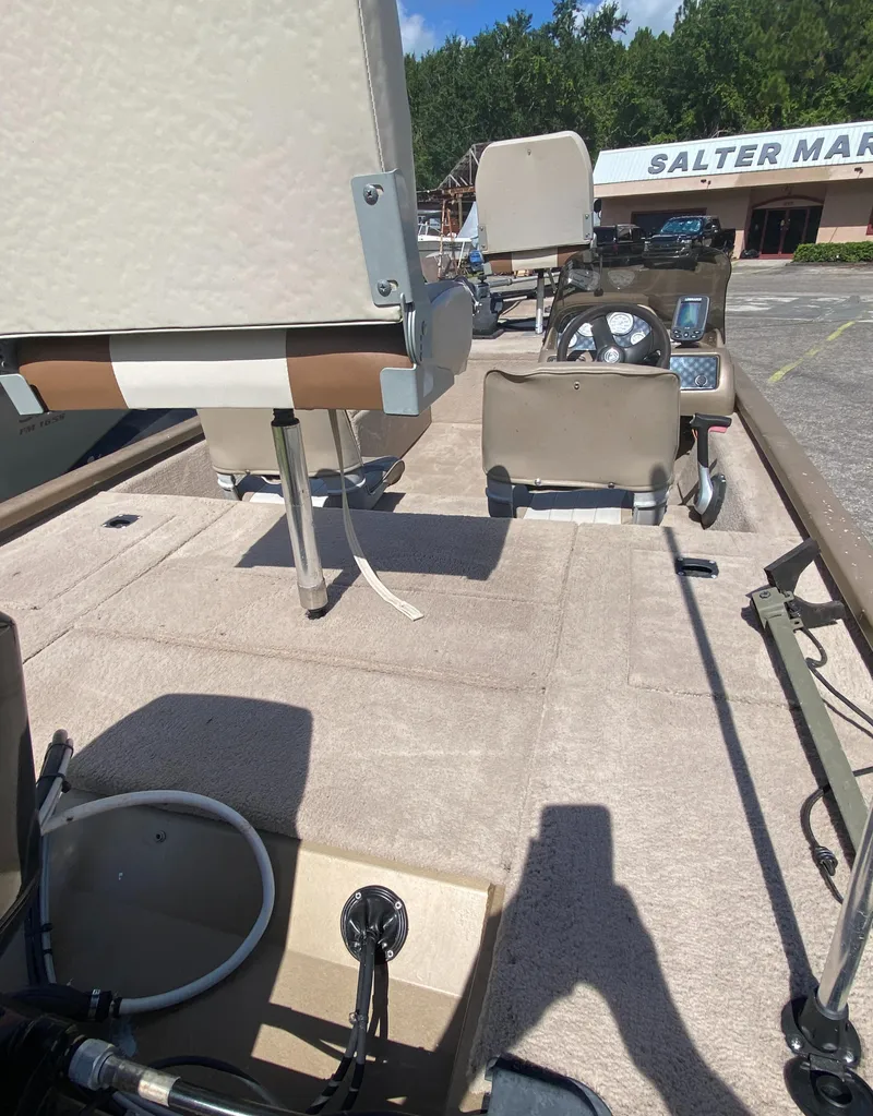 Slide: The Image of 2006 Fisher 1600 boat with Mercury engine on trailer, parked outdoors under blue sky. - 3