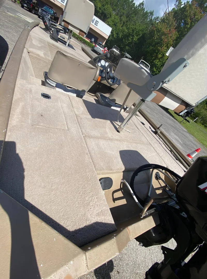 Slide: The Image of 2006 Fisher 1600 boat interior with steering wheel and seating, parked outdoors. - 5